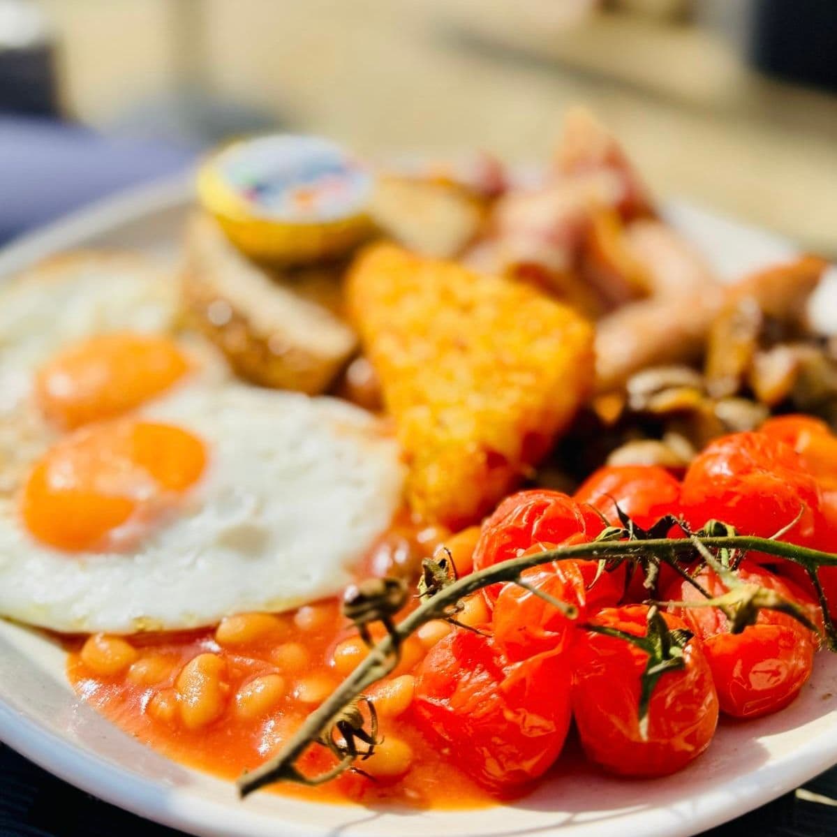 Cooked breakfast with eggs, tomatoes and golden hash browns